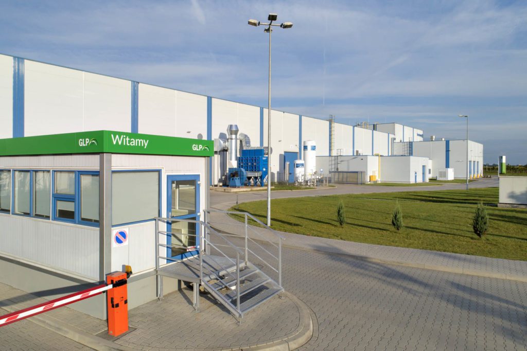 Exterior of Wroclaw IV Logistics Centre showing pavement, grass and entry point.