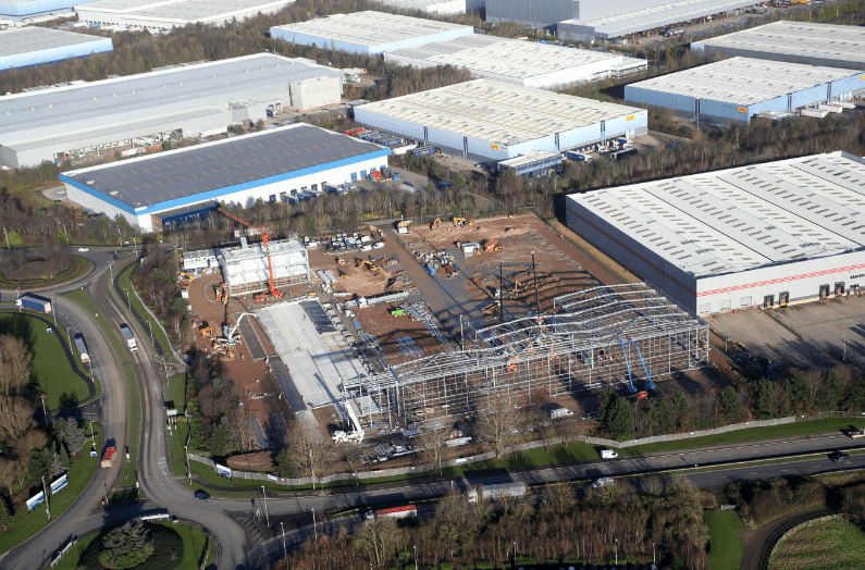 Birds-eye-view of a GLP logistics centre under construction surrounded by complete GLP logistics centres.