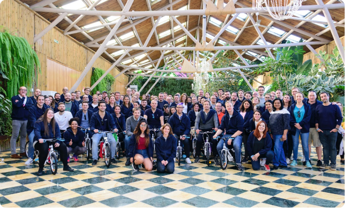 Members of the GLP Europe team gather together for a group photograph, some on bicycles