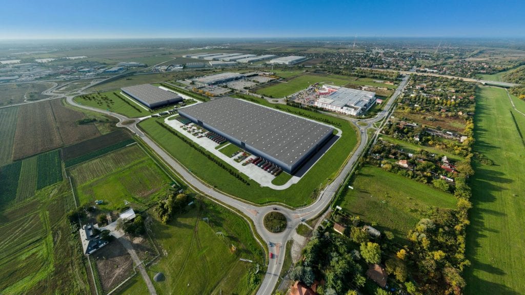 Distant birds-eye-view of a GLP logistics centre showing many connected routes surrounded by nature.