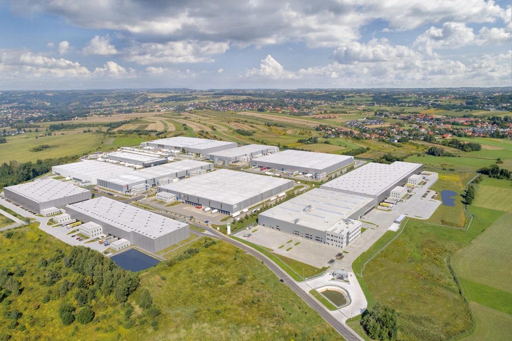 A GLP Logistics complex from a distance, showing nine different warehouse structures, fields, surrounding villages and connecting roads.