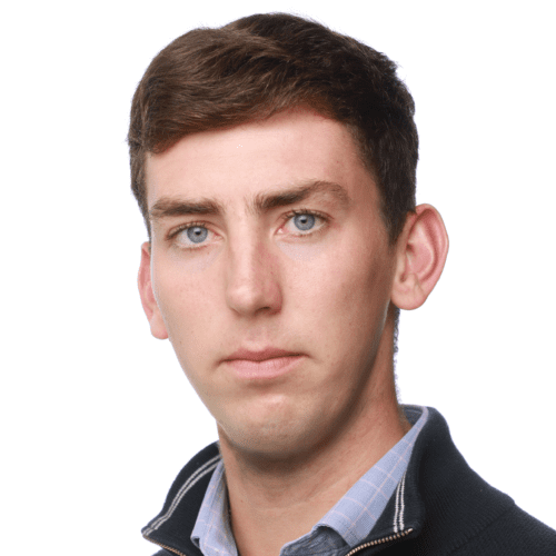Headshot of Spencer Alderton, with dark brown short hair and wearing a navy fleece with a light blue checked shirt