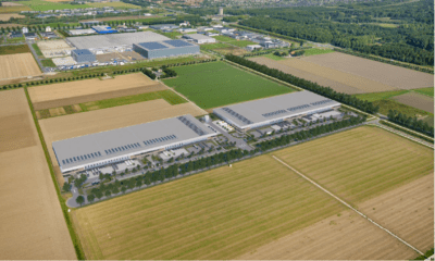 Aerial shot of G-Park Lelystad, with large grey warehouses surrounded by fields.