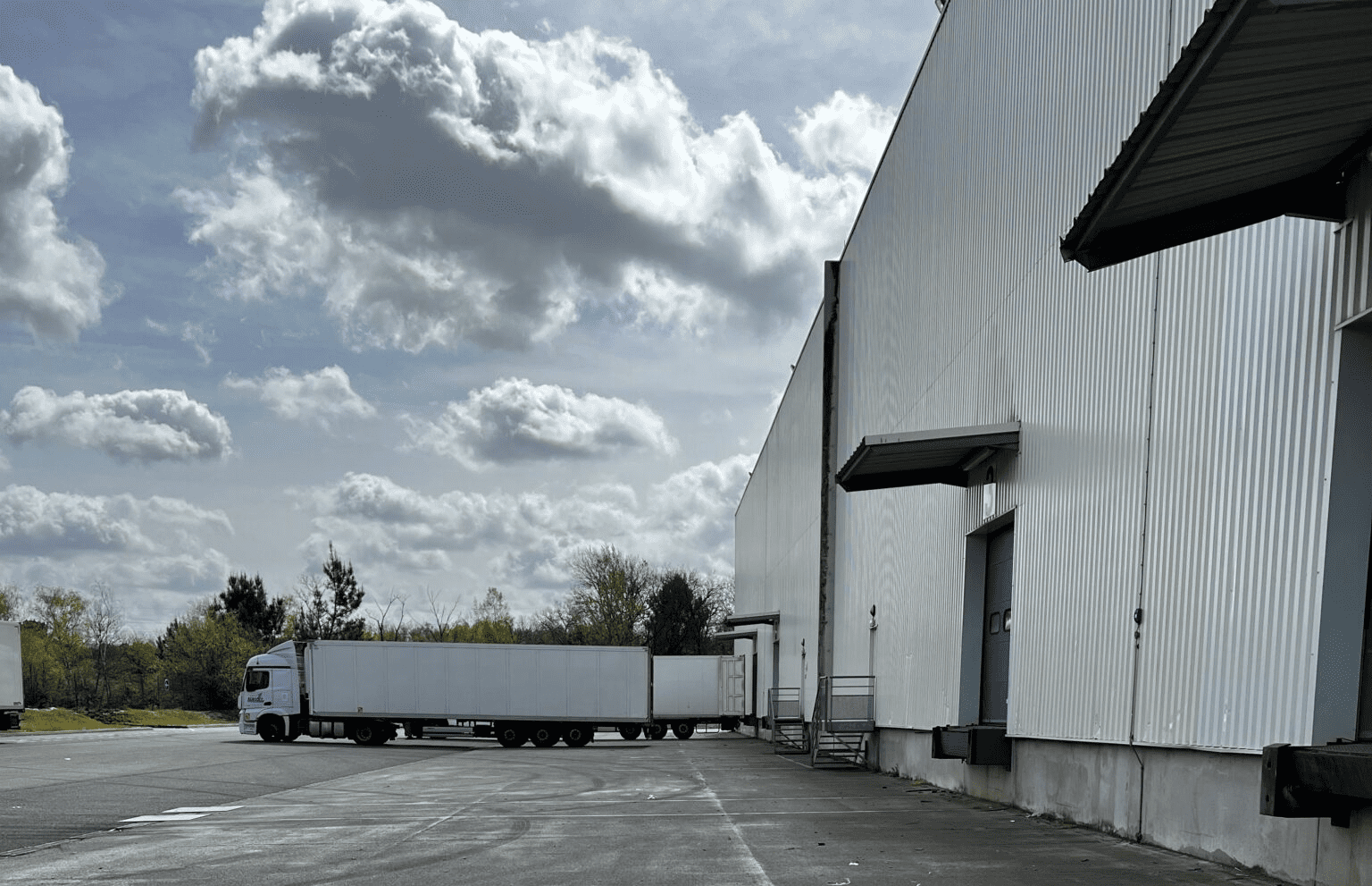 Exterior of GLP Park Cestas 2 showing trucks lined up at loading bays under a cloudy sky